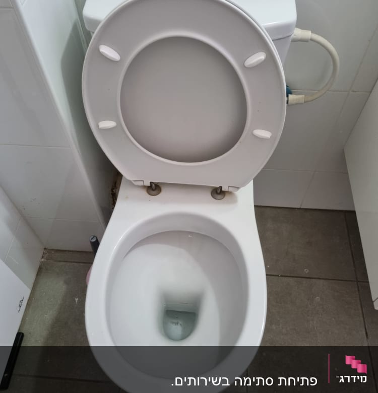 אסלה עם מכסה פתוח וצינור מים מחובר